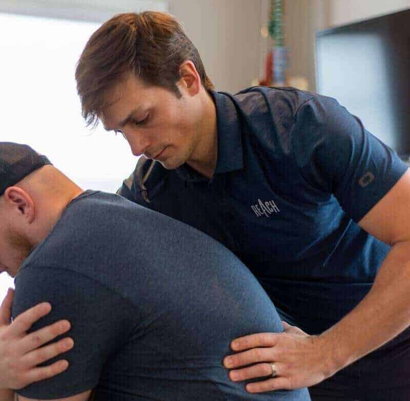 Dr. RJ Burr treating a patient at REACH Rehab + Chiropractic in Plymouth, MI